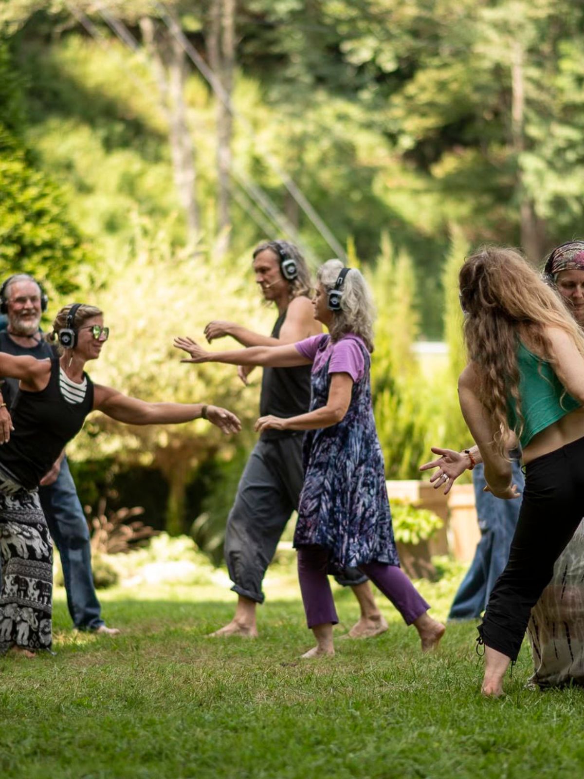 Group dancing with headphones on a garden lawn