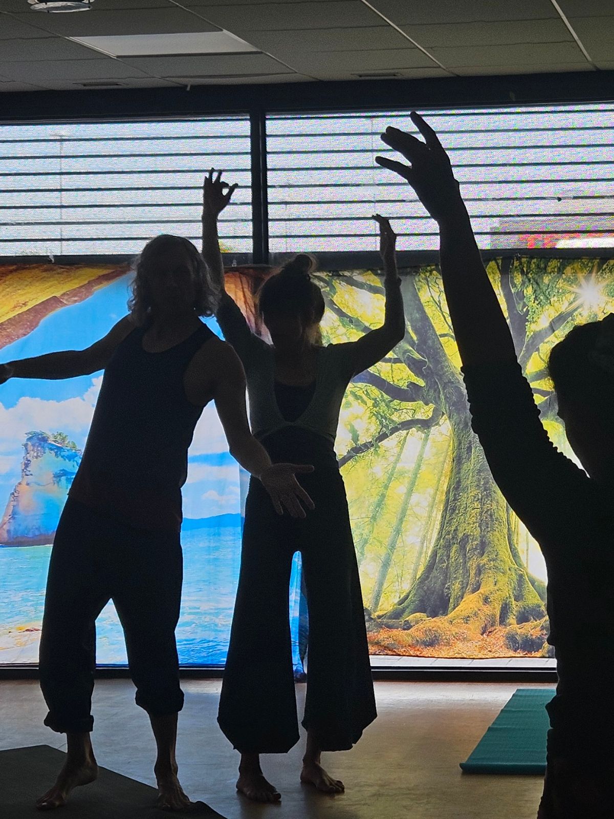 Silhouettes of dancers with raised arms indoors